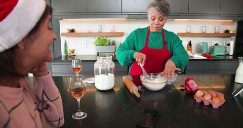 Hispanic grandmother baking with daughter in cozy kitchen setting