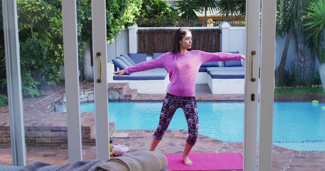 Biracial woman practicing yoga on mat in garden. Beauty, health and female spa home concept.