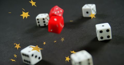 Falling Dice Surrounded by Golden Stars on Gray Background