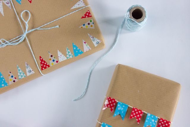 Handcrafted gift packages decorated with colorful triangular patterns and bound with light blue twine. Ideal for holiday presents, birthdays, or celebrations, offering a personalized and creative touch. Suitable for use in DIY craft tutorials, gift wrapping instructional content, or festive decoration ideas.