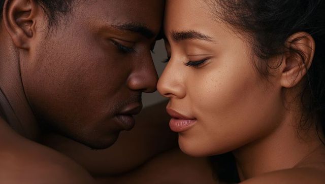 Intimate closeup of couple pressing foreheads and noses together, tender skin texture