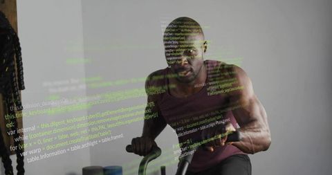 Muscular man pedaling air bike with battle ropes and code overlay for fitness tech
