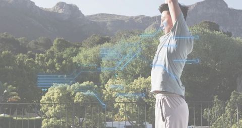 Asian man stretching and raising arms on terrace with fitness tech overlay for wellness