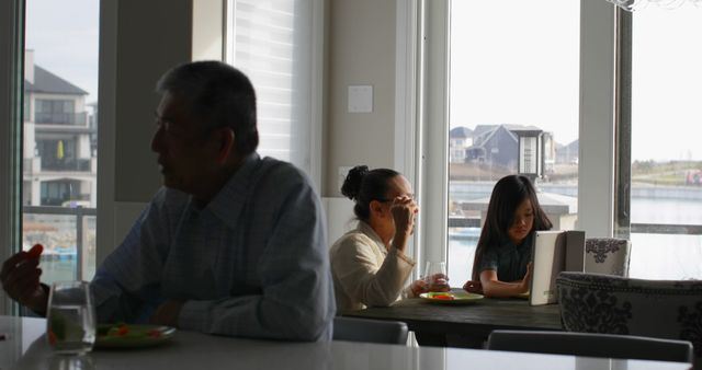 Multi-generation family having breakfast together by large window - Download Free Stock Images Pikwizard.com