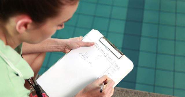 Coach Writing Athlete Progress on Clipboard Near Swimming Pool - Download Free Stock Images Pikwizard.com