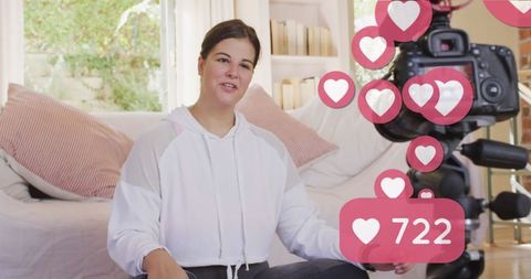 Female vlogger recording yoga vlog at home with social media likes