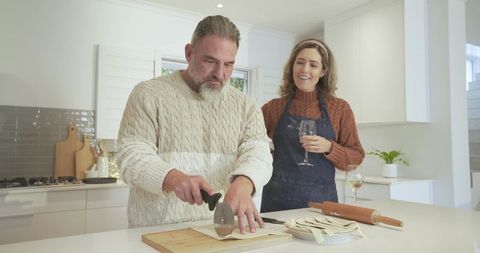 Couple preparing homemade pasta in modern kitchen