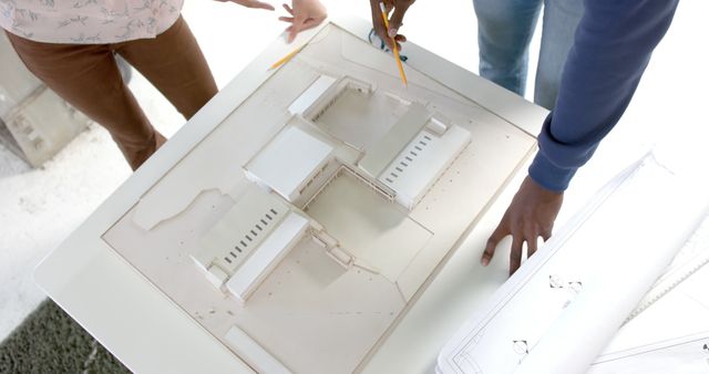 Architects Discussing Blueprint Layout Over Architectural Model - Download Free Stock Images Pikwizard.com