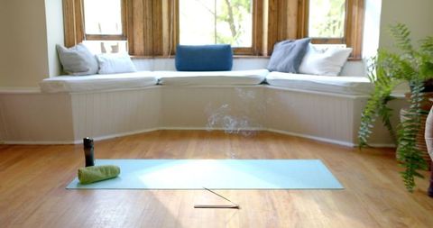 Peaceful Yoga Space with Incense on Light Blue Mat by Sunlit Window Nook