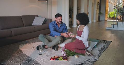Couple Enjoying Romantic Indoor Picnic with Wine and Snacks