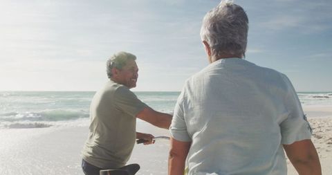 Senior Couple Enjoying Beach Cycling During Sunset