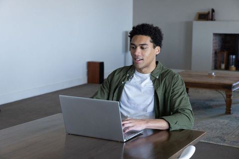 Young African American Man Working on Laptop in Cozy Living Room