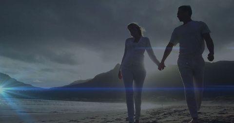 Romantic Mature Couple Walking on Beach at Dusk
