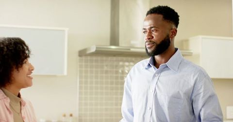 African american couple talking in modern kitchen during casual morning conversation
