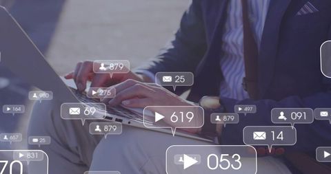 Asian businessman typing on laptop with social media and video notification overlays
