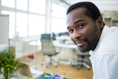 Confident Professional Reviewing Designs in Modern Office