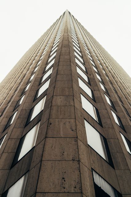 Use this image for articles, advertisements, or websites related to urban development, modern architecture, engineering, or city life. The upward perspective emphasizes the height and grandeur of the building, making it suitable for promotions or visuals seeking to evoke a sense of innovation, growth, or metropolitan lifestyle.