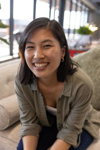 Young Professional Smiling in Modern Office Setting by Windows