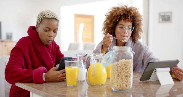 Two Women Enjoying Breakfast and Using Digital Devices at Home - Download Free Stock Images Pikwizard.com