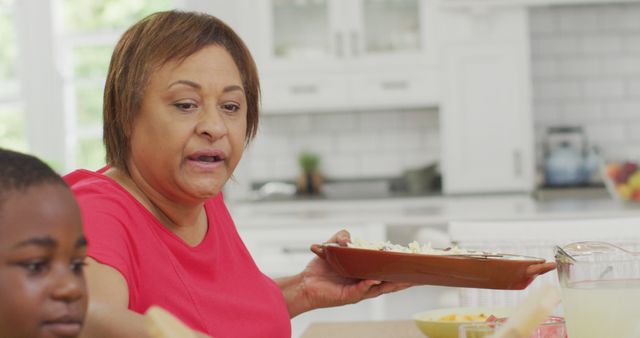 Grandmother Serving Food to Family Near Table in Kitchen - Download Free Stock Images Pikwizard.com