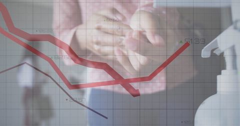 Woman sanitizing hands amidst downward economic chart