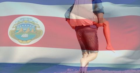 Couple carrying piggyback on costa rica beach with flag overlay romantic travel concept