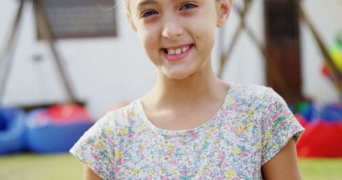 Cheerful Young Girl Smiling in Sunny Playground Setting