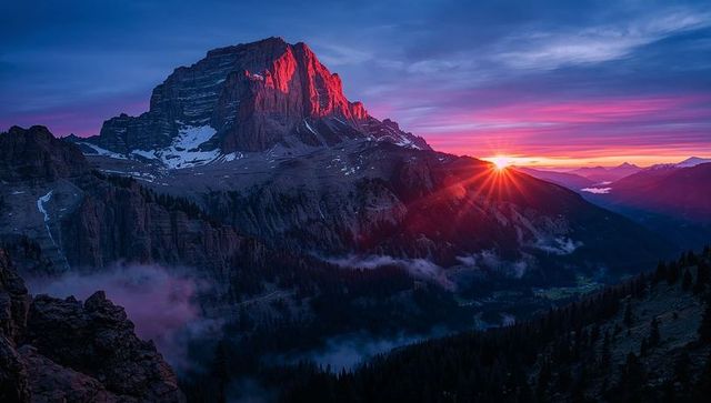Alpenglow Sunrise on Rugged Mountain Peak with Sun Starburst and Misty Alpine Valley