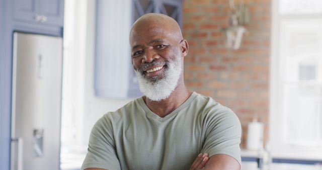 Portrait of african american senior man with arms crossed smiling at home. retirement senior lifestyle living concept