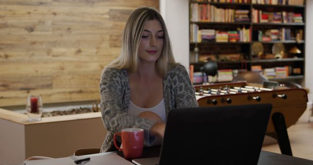 Woman Working on Laptop at Home with Coffee Mug in Hand - Download Free Stock Images Pikwizard.com