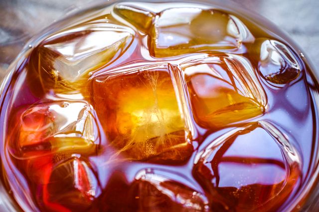 Closeup view of a refreshing iced coffee with clear ice cubes, perfect for showcasing cold beverages in a café or drinks menu. Ideal for marketing summer drinks, iced coffee products, or promoting refreshing beverages on social media and websites.