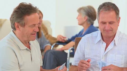 Senior Friends Enjoying Card Game in Living Room Setting
