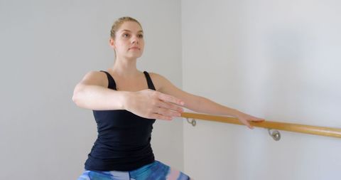 Focused Woman Performing Stretch at Gym Ballet Barre - Download Free Stock Images Pikwizard.com
