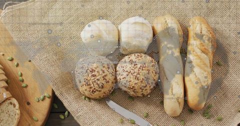 Artisan bread and rolls on rustic burlap with pumpkin seeds and wooden cutting board