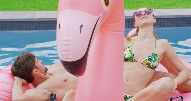 Couple Relaxing on Inflatable Flamingo Float in Swimming Pool - Download Free Stock Images Pikwizard.com