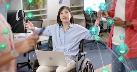 Businesswoman in wheelchair leading inclusive team meeting with laptop and ar visualizations