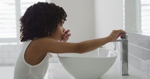 Young boy practicing handwashing routine at home bathroom