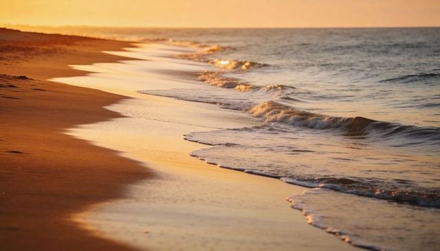 Glistening shoreline reflecting golden sunset light on tranquil sandy beach at dusk