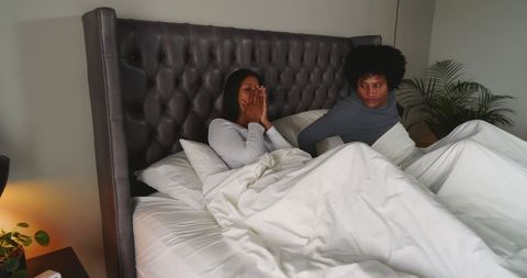 Couple enjoying morning relaxation in comfortable modern bedroom