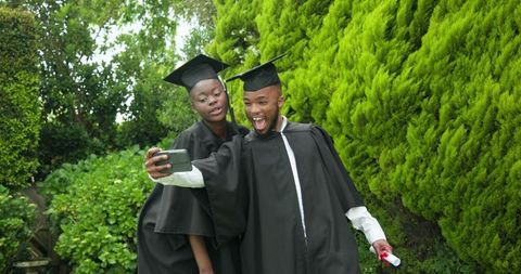 Joyful Graduating Students Taking Selfie with Diploma Outdoors