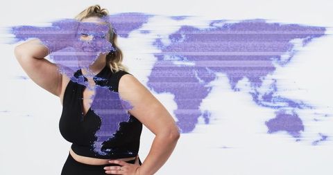 Plus-size model posing in black crop top with purple glitch world map overlay