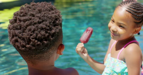 Children Enjoying Popsicles by the Pool on Sunny Day