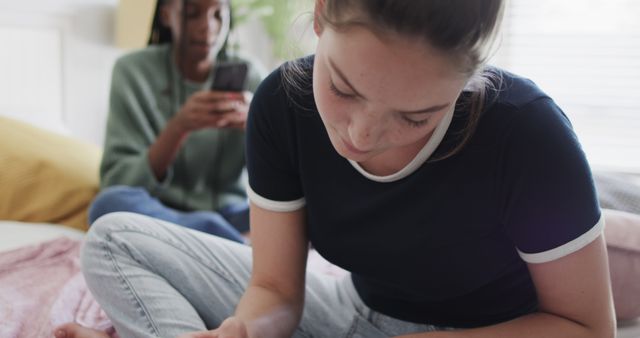 Teenage Girls Relaxing: One Reading, One Using Smartphone at Home - Download Free Stock Images Pikwizard.com