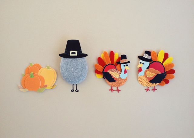 Thanksgiving craft decorations featuring colorful paper turkeys, pumpkins, and a rock wearing a Pilgrim hat, ideal for holiday crafting projects, classroom activities, or home decor. Perfect for adding a festive touch to Thanksgiving celebrations.