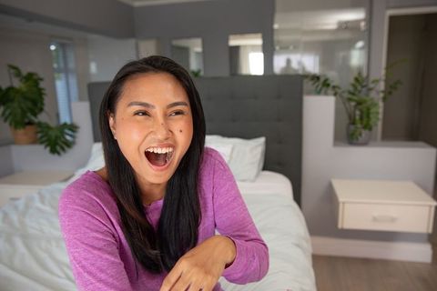 Smiling Asian Woman Relaxing at Home in Comfortable Setting