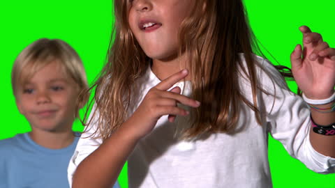 Siblings Enjoy Playtime in Front of Green Screen