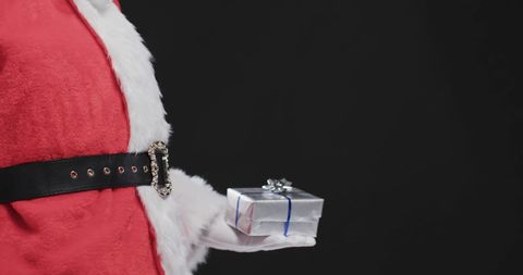 Santa claus holding gift box in festive atmosphere