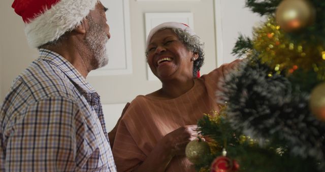 Image of happy african american senior couple decorating christmas tree together - Download Free Stock Photos Pikwizard.com