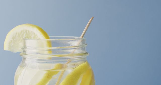 Image of jar with lemonade and straw on blue background. drinks, beverages, freshens and refreshment concept.
