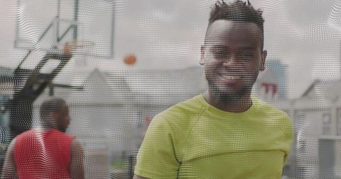 Smiling man on urban basketball court wearing lime-green t-shirt